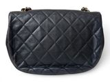 a black quilted purse on a white background