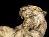a marble statue of a cat with yellow eyes
