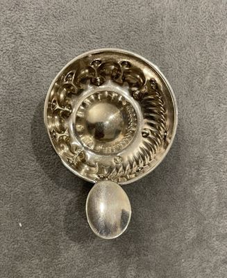 une cuillère en argent et un repose-cuillère posés sur une table
