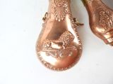 pair of antique copper spoons on a white surface