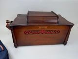 a small wooden box with a lid on a white table