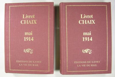deux livres posés sur une table blanche, avec une couverture rouge et des lettres dorées