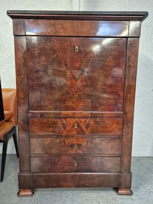 une commode en bois avec des tiroirs et une chaise à côté