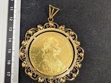 une pièce d'or tenue par un souverain