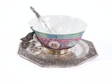 a silver plate with a bowl and spoon on it