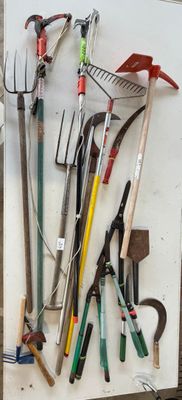 de nombreux outils de jardinage de toutes sortes accrochés au mur