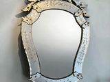 a mirror hanging on the wall with a bird on it