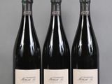 three bottles of wine are lined up on a table