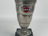 tasse argentée sur un socle noir, ornée du logo Martini
