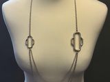 a white mannequin torso with a silver necklace on it