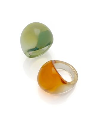 deux anneaux en verre de couleurs différentes posés sur une surface blanche
