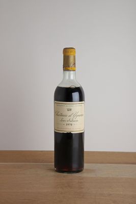 une bouteille de vin rouge posée sur une table en bois, avec un mur blanc en arrière-plan