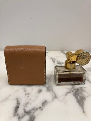 an image of a bottle of perfume sitting on a marble counter