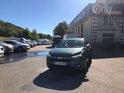 des voitures garées sur un parking devant un immeuble, avec le ciel en arrière-plan