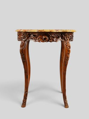 une petite table avec un plateau en marbre et des pieds sculptés