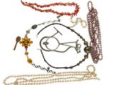 a lot of different necklaces and bracelets on a white background