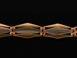 a close up of a gold and black bracelet
