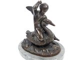 bronze statue of a boy on a rock with a bird in his hand