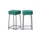 two green stools sitting next to each other on a white surface