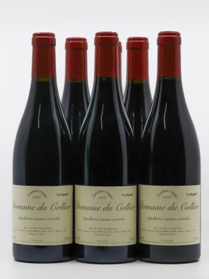 quatre bouteilles de vin rouge sont alignées sur une surface blanche