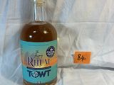 a bottle of rum sitting on a bed with a price tag
