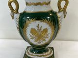 a green and white vase with gold decoration on it