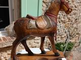 a wooden horse that is on a table outside