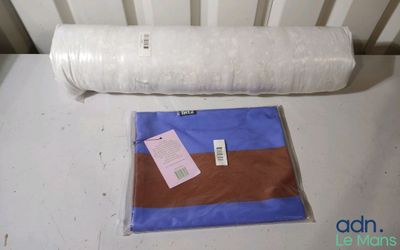 un rouleau de tissu posé sur une table à côté d'un oreiller