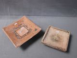 pair of small brown ceramic bowls with square designs on them