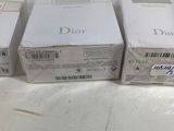 three boxes of dior perfume sitting on top of a white table