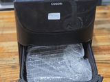 a black suitcase with plastic wrap inside of it on a wooden table