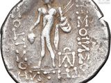 an ancient silver coin with a woman holding a sword