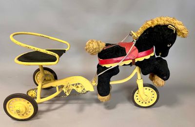 a black horse pulling a yellow tricycle with a red seat