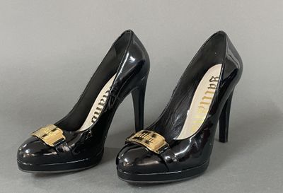pair of black high heeled shoes with gold buckles on them