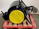 a large black barrel on a pallet with a yellow wheel