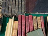 beaucoup de livres posés sur une table, avec la photo d'un homme