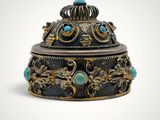 an ornately decorated box with turquoise stones on a white background