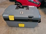 a tool box sitting on the floor next to a moped