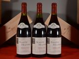 three bottles of wine sit on a red table cloth next to a wooden crate