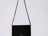 a black and white purse with a chain hanging from it ' s side