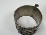 an old silver bracelet with blue and green stones on it