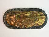 a gold statue of a woman on a black tray