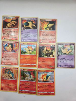 Plusieurs cartes Pokémon sont accrochées au mur d'une pièce.