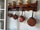 pots and pans are hanging on a rack in a kitchen