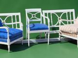 trois chaises blanches avec des coussins bleus, sur fond vert