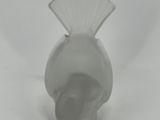 a small white vase with a fan on top of it