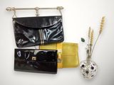 two black and yellow purses and a vase with flowers