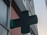 a green cross sign on the side of a building