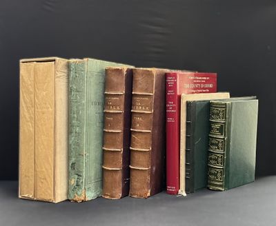 several old books are lined up in a row on a table
