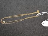 a close up of a necklace with a tag attached to it